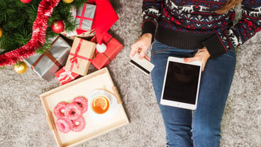 Young woman holding credit card and tablet on Christmas