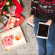 Young woman holding credit card and tablet on Christmas