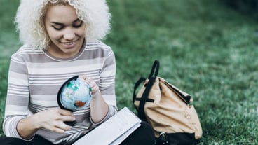 Student studying outdoors on the grass