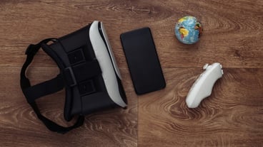 Virtual reality headset with joystick and smartphone, globe on wooden background. Virtual travel.