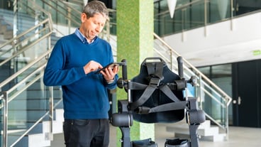 Mechanical exoskeleton computer engineer looking at the robot with a tablet Physiotherapy in a modern hospital Robotic skeleton Physiotherapy Rehabilitation Scientists Engineers and Physicians