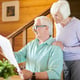 Happy mature man and his wife reading latest news in newspaper in the morning after breakfast