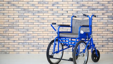 Blue wheelchair near brick wall indoors