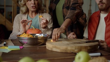 Middle section of a woman preparing food at a table