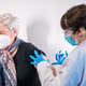 An elderly woman receiving the injection of the coronavirus vaccine by a doctor to receive the antibodies, immunize the population.