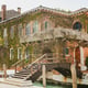 Terrace in Venice with a floral patio. House with a facade overgrown with grape hole. Bridge over the venetian canal.