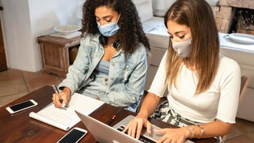 High angel view of businesswoman wearing mask working at home