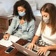 High angel view of businesswoman wearing mask working at home