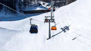 Empty bright orange ski chair lift in mountains winter against snow Alpine skiing and snowboarding