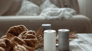 Cozy home composition with extinguished candles on a wooden table with a knitted element.