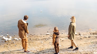 Father teaching little son throw rocks in water