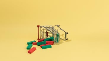 Japanese candles falling from a shoping cart on a yellow background exchange stock market