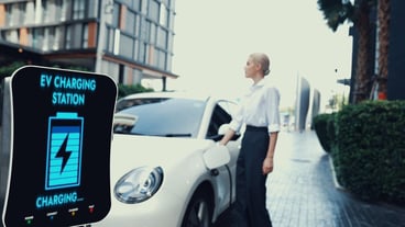 Businesswoman recharge her electric car from charging station Peruse