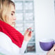 Sick woman in bed measures temperature