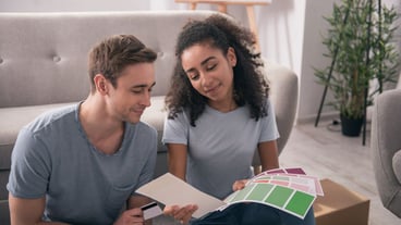 House design. Joyful young couple looking together at the colors while choosing house design