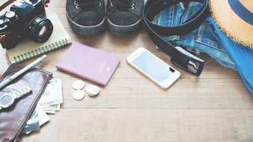 Travel accessories, essential vacation items for young man with passport, camera, mobile device and wallet on wooden background with copy space