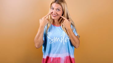Young blonde girl smiling at the camera wearing a tshirt with the title quotsmilequot Smile concept