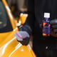 Cropped image of hands of male service worker in protective gloves applying special polish cream