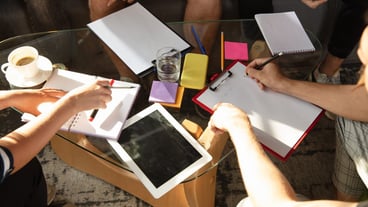 Group of young Caucasian office workers meeting to discuss new ideas. Creative meeting. Teamwork and brainstorming. Men and women meet in the office to plan their future work. Business concept.