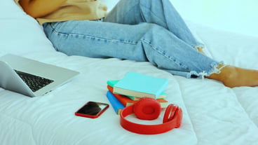 The portable education accessory portable education accessory mobile books headpones in bed with Asian woman background.