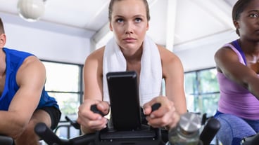 Fit woman exercising on exercise bike in gym