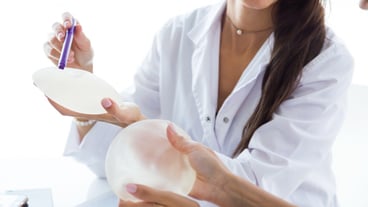 Doctor and her patient choosing mammary prosthesis in the office.