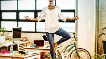 Female business executive performing yoga