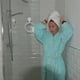 Woman wearing bathrobe and towel drying hair in bathroom