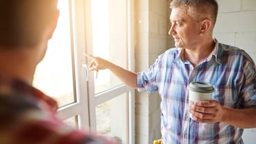 Handsome young carpenter working with an experienced man