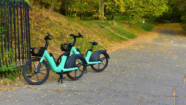 Two blackandgreen bicycles parked near a metal gate Street transport Poland Poznan