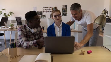 Business colleagues discussing over laptop in office