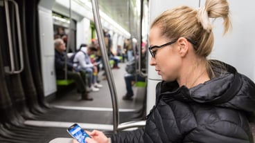 Young woman using mobile phone in bus