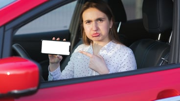 Mobile application for environmentally friendly transportation. Charging electric car and watching the application on the cell phone. Close to smart phone screen. Hand holding smart device with blank screen.