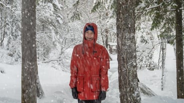 Portrait of teenage boy walking and having fun in winter snowing forest