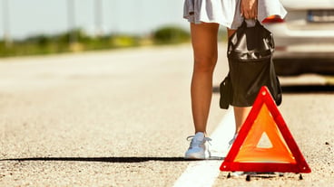 The young couple broke down their car during a road trip. They are trying to stop other drivers and ask for help or hitchhike. Relationship, problems on the road, vacation.