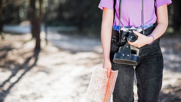 Crop woman with camera and map