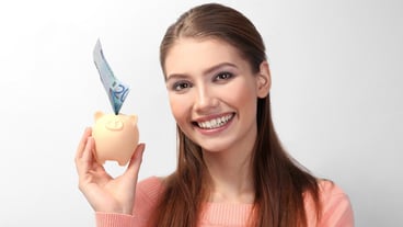 Beautiful young woman with piggy bank on light background