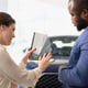Car showroom agent providing customer with color wheel tinting selection