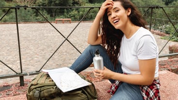 Smiley female traveling stop to hydrate