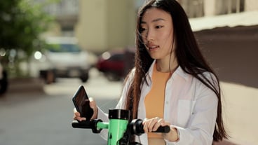 Young asian woman take electric scooter sharing parking lot tourist phone application woman using phone application to rent an electric scooter