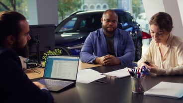 Agent discussing with couple wanting to lease vehicle close up