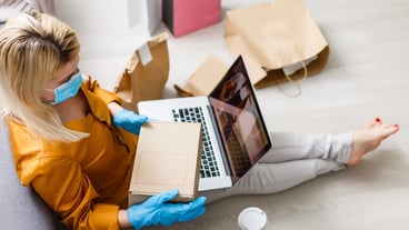 Young people in self-quarantine at home order products online. Quarantine work from home. Masked new family life with coronavirus isolation. Remote work on a computer. Pandemic lifestyle.