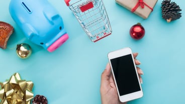 Hand holdin smart phone with Christmas decorations. Christmas mock template for online shopping concept. View from above