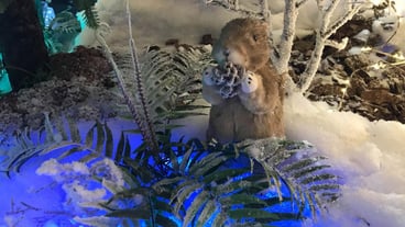 Toy squirrel or gopher sitting on a fluffy fir branches Merry Christmas and Happy New Year