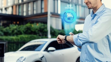 Progressive businessman check wearable hologram watch on EV car battery's status