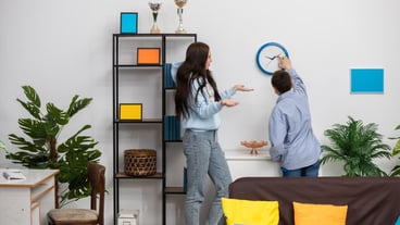 Creative friends collaborating to enhance a modern living room by making it cozy and stylish.