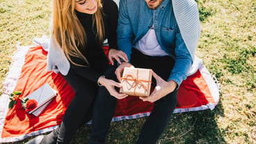 Cheerful young couple with anniversary present