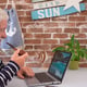 Senior man smoking pipe using laptop to see photographs of the sea. Brick wall in the background and decorations