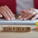 It career words collected from wooden cubes and stack of note papers on table female programmer