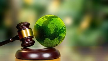 International Environmental law concept World and gavel with scales of justice and hammer on a green